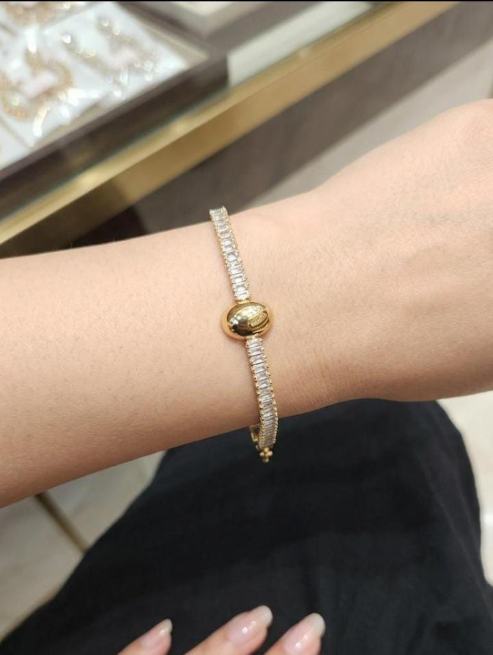 A dazzling silver-tone tennis bracelet made entirely of emerald-cut crystals, offering a clean, geometric sparkle. A timeless piece that pairs well with both casual and formal looks.